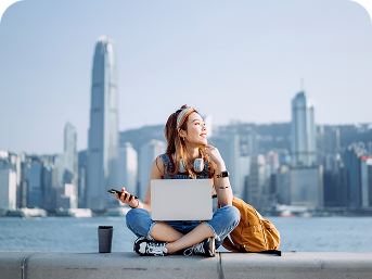 Woman with laptop by Hong Kong harbor